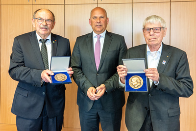Auf dem Bild: Innenminister Roman Poseck mit Horst Nierichlo (links) und Gerd Höfer (rechts) 